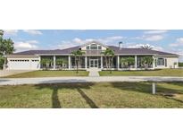 Spacious ranch-style home with a metal roof, large screened porch, and a well-manicured front lawn at 7200 Riverside Dr, Punta Gorda, FL 33982