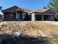 A charming single-story home featuring an attached two-car garage and a welcoming front porch at 112 Cougar Way, Rotonda West, FL 33947