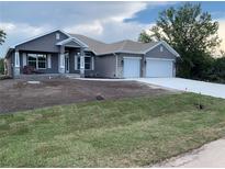 Beautiful single-story home featuring a 2-car garage, well-manicured lawn, and neutral-colored stucco finish at 112 Cougar Way, Rotonda West, FL 33947
