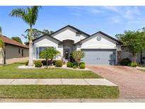 Charming single-story home featuring a brick driveway and well-manicured lawn and landscaping at 15193 Mille Fiore Blvd, Port Charlotte, FL 33953