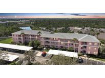 Three-story condo building featuring covered parking and tropical landscaping at 2061 Willow Hammock Cir # 303, Punta Gorda, FL 33983