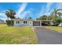 Charming single-story home with well-maintained lawn, driveway, and carport at 23491 Harper Ave, Punta Gorda, FL 33980