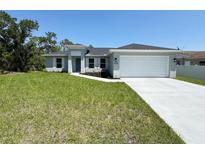 Charming single-story home featuring a well-manicured lawn, two car garage and pleasant landscaping at 4336 Blackman St, North Port, FL 34291
