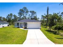 Charming single-story home with a well-manicured lawn, a two car garage, and a long driveway at 4880 Cornsilk Ter, North Port, FL 34286