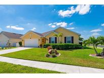 Well-manicured lawn and tidy flowerbeds surround this charming single-story home at 7501 Mikasa Dr, Punta Gorda, FL 33950