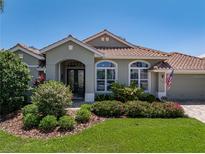 Charming single-story home with a well-maintained lawn, mature landscaping, and a beautiful tiled roof at 13761 Long Lake Ln, Port Charlotte, FL 33953