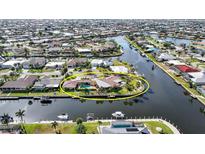 Waterfront home on a canal with a pool and dock, surrounded by lush landscaping at 1796 Boca Raton Ct, Punta Gorda, FL 33950