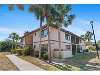 Multi-Gathering home with lush landscaping featuring mature palm trees under a clear blue sky on a sunny day at 19505 Quesada Ave # Pp201, Port Charlotte, FL 33948