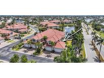 Stunning waterfront villa with a red tile roof, lush landscaping, and a three-car garage at 196 Tarpon Cove Blvd # 722, Punta Gorda, FL 33950