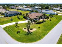Expansive single-story home with a well-manicured lawn, circular driveway, and a screened-in pool at 25179 Campos Dr, Punta Gorda, FL 33983