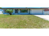 Charming single-story home featuring a well-maintained front yard and attached one-car garage at 309 Aurora St, Port Charlotte, FL 33948
