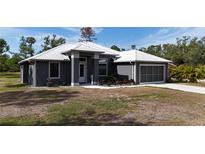 Charming single-story home featuring a modern metal roof and a well-manicured lawn at 3136 Joshua St, Port Charlotte, FL 33948