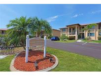 Well-maintained condo complex with lush landscaping, a community sign and ample parking on a clear sunny day at 3221 White Ibis Ct # D2, Punta Gorda, FL 33950