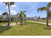 Charming single-story home with beautiful landscaping, palm trees and a well-maintained lawn at 3305 Blue Jay Ln, Englewood, FL 34224