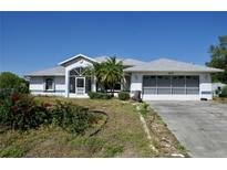 Charming single Gathering home with a two car garage, mature landscaping, and blue accents at 5050 Prosch Cir, North Port, FL 34288