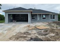 New construction home featuring a gray exterior, garage, and architectural windows at 7 Pine Valley Ct, Rotonda West, FL 33947