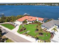 Beautiful waterfront home with lush landscaping, a private dock, and a screened-in pool, showcasing a luxurious coastal lifestyle at 8115 Manasota Key Rd, Englewood, FL 34223