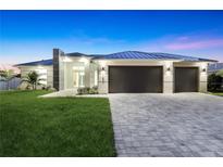 Stunning modern home boasts clean lines, a metal roof, a spacious driveway, and a manicured front lawn at 10522 Riverside Rd, Port Charlotte, FL 33981