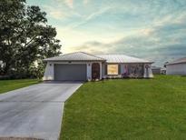 Charming single-story home featuring a well-maintained lawn and neutral exterior paint at 1210 Marlow St, Port Charlotte, FL 33952