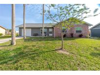 Charming home with a well-maintained lawn, colorful shrubs, and a brick facade at 13449 Muriel Ave, Port Charlotte, FL 33981