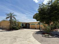 Inviting single-story home boasting a lush landscaped yard, a two-car garage, and a charming covered entry at 187 Beeney Se Rd, Port Charlotte, FL 33952