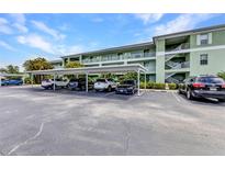 Exterior view of assigned parking and a stairway in front of this lovely, multi-story condo building on a sunny day at 2020 Willow Hammock Cir # 302, Punta Gorda, FL 33983