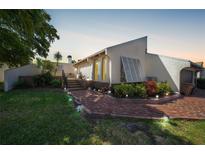 Charming home exterior with a brick path, lush landscaping, and a glimpse of the cozy front porch at 25188 Marion Ave # 10, Punta Gorda, FL 33950