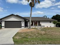 Charming single-story home with a brown roof, light stucco, brown trim, and well-manicured landscaping at 376 Waterside St, Port Charlotte, FL 33954