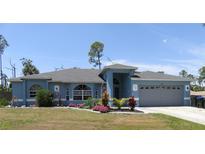 Charming single-Gathering home featuring a well-manicured lawn, mature landscaping and a two-car garage at 4309 Badali Rd, North Port, FL 34286