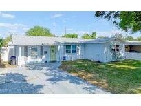 Charming single-story home with a light-blue painted exterior, neat landscaping, and a gray paved driveway at 8795 56Th N St, Pinellas Park, FL 33782