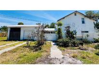 Exterior view of a home with a detached garage and ample yard space at 899 S Broadway, Englewood, FL 34223