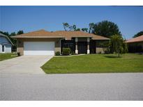 Well-maintained one-story home featuring a two-car garage, landscaping, and a manicured lawn at 98 Valdiva St, Punta Gorda, FL 33983