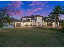 Elegant two-story home boasts a manicured lawn, tile roof, and multiple garages for ample parking at 10580 Poughkeepsie Cir, Port Charlotte, FL 33981
