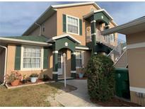 Inviting two-story home featuring green shutters, a matching roof, and a stairway to a private entrance at 224 Boundary Blvd # 224L, Rotonda West, FL 33947