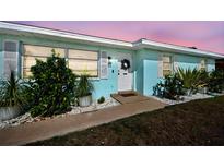 Charming entry with blue walls, white door, and decorative wreath in a well-maintained front yard at 4097 Rose Arbor Cir, Port Charlotte, FL 33948