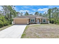 Charming one-story home with a well-manicured lawn and a two-car garage, nestled among tall pine trees at 7135 Tropicaire Blvd, North Port, FL 34291