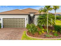Charming single-story home featuring a well-manicured lawn, beautiful landscaping, and brick driveway at 1745 Hyssop Loop, North Port, FL 34289