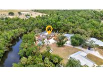 Stunning aerial view of a waterfront home with a private pool nestled among lush greenery at 3400 Allapatchee Dr, Punta Gorda, FL 33950