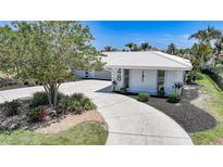 Beautiful house exterior with a well manicured yard and a white tiled roof at 48 Hibiscus Dr, Punta Gorda, FL 33950