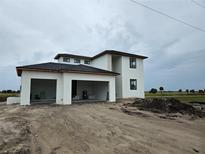 Modern two-story home featuring a white exterior, black trim, and an attached two-car carport at 7 Sunflower Dr, Placida, FL 33946