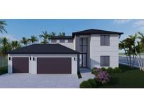 Modern two-story home features a two-car garage, neutral stucco exterior, and black trim in tropical landscaping at 7 Sunflower Dr, Placida, FL 33946