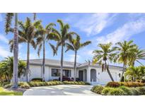 Charming single-story home boasting a well-manicured lawn and lush palm trees, perfect for a serene coastal living at 80 Hibiscus Dr, Punta Gorda, FL 33950