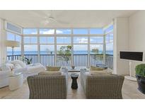 Bright sunroom with waterfront views features comfortable seating and access to a private balcony at 95 N Marion Ct # 135, Punta Gorda, FL 33950