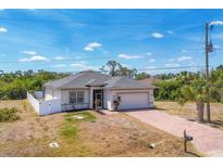 Charming single-Gathering home with a well-maintained lawn, a two-car garage, and a brick-paved driveway at 118 Boxwood Ln, Rotonda West, FL 33947