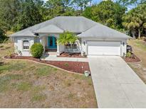 Well-maintained home with a concrete driveway, two-car garage, and landscaped front yard at 1313 Wise Dr, North Port, FL 34286