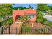 Charming coral stucco home featuring an arched entryway, red tile roof and well-manicured landscaping at 2002 Central Ave, Sarasota, FL 34234