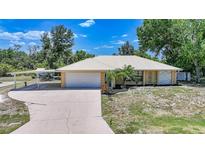 Inviting single Gathering home with a well manicured front yard, attached two car garage and covered parking area at 22435 Fortune Ave, Port Charlotte, FL 33954