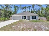 Charming single-story home featuring a neutral palette, an attached two-car garage, and a well-maintained front yard at 23470 Burlingame Ave, Punta Gorda, FL 33980