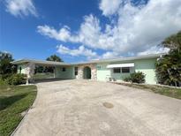 Charming single-story home with a spacious driveway and attached carport provides ample parking at 2500 Aquilos Ct, Port Charlotte, FL 33952