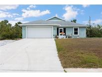 Charming single-story home with an attached two-car garage and a well-maintained front lawn and inviting curb appeal at 7122 Turner St, Englewood, FL 34224